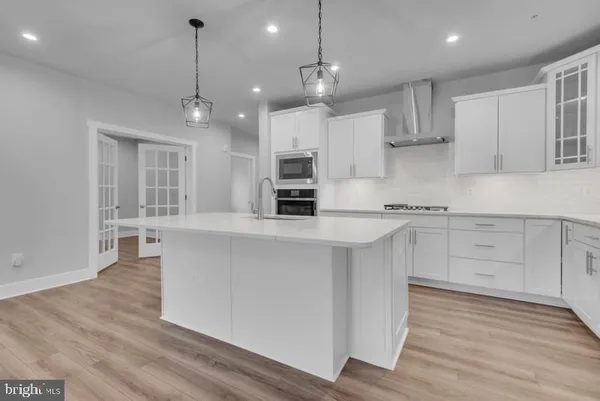 a view of an empty room and kitchen with window wooden floor and kitchen