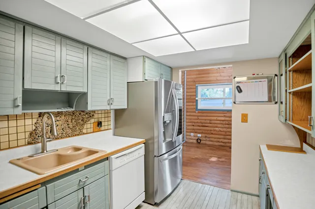 a kitchen with a sink cabinets stainless steel appliances and a window
