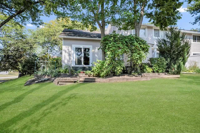 a view of a house with a yard and sitting area
