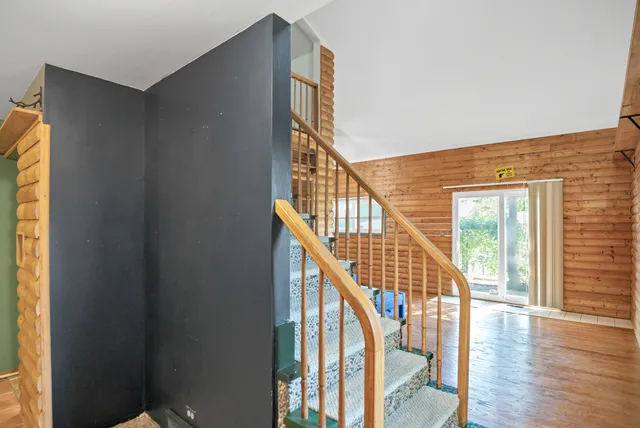 a view of staircase with railing and a window