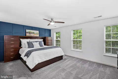 a spacious bedroom with a bed a window and closet