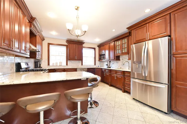a large kitchen with a table chairs refrigerator and cabinets