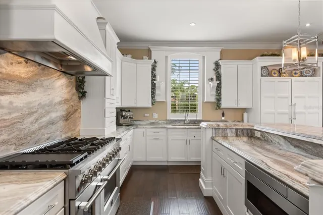 a kitchen with white cabinets and stainless steel appliances