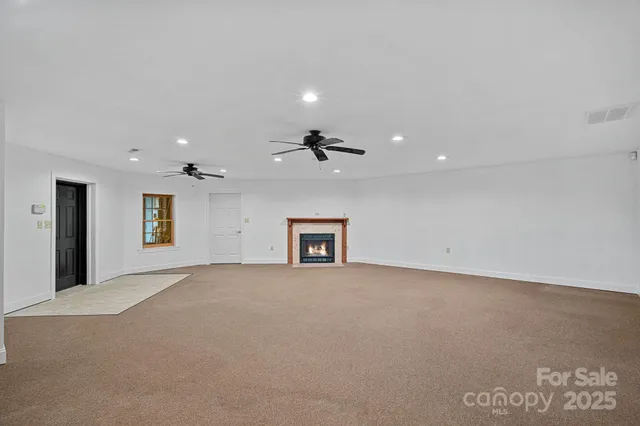 an empty room with windows and ceiling fan