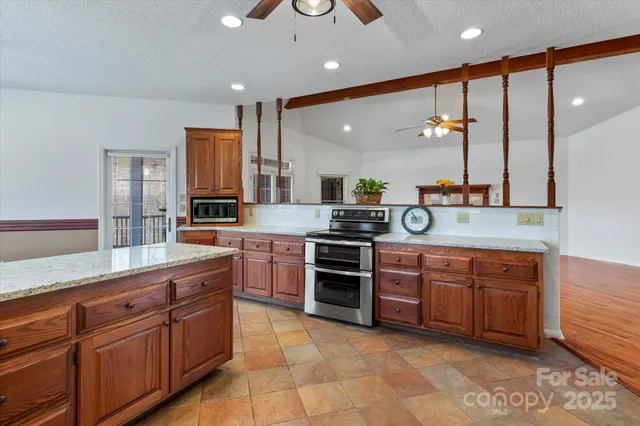 a large kitchen with a large counter top sink and stainless steel appliances