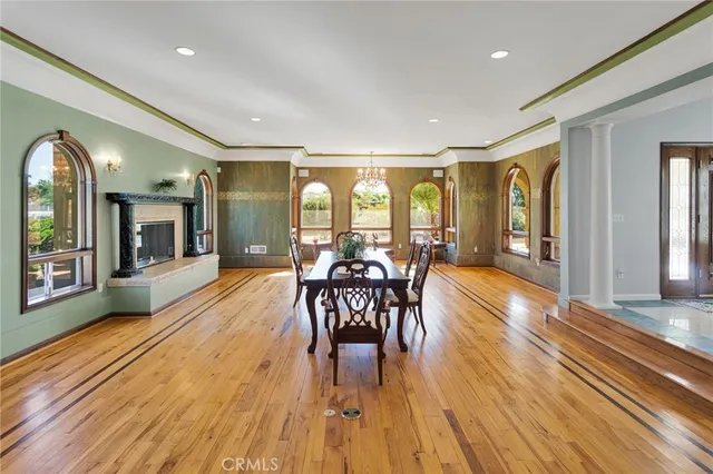 a view of a a dining room with furniture window and wooden floor