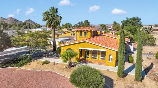an aerial view of a house with a yard and trees