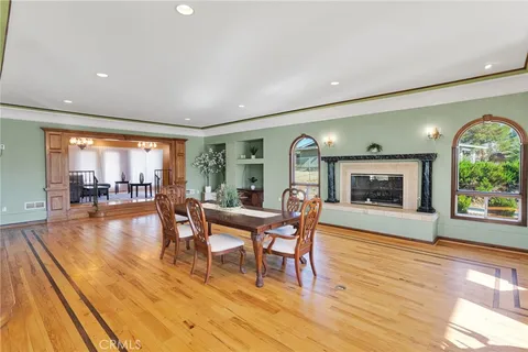 a dining room with furniture a fireplace and wooden floor