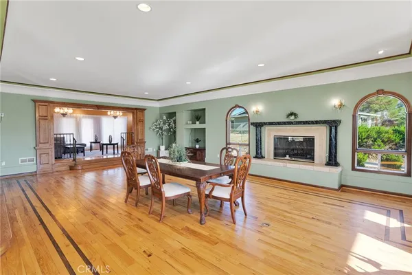 a dining room with furniture a fireplace and wooden floor