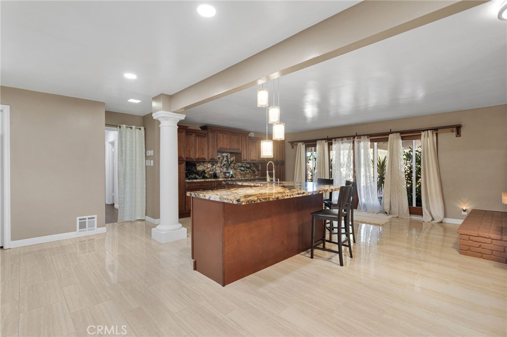 15023 Genesee Road Apple Valley, CA 92307 - Photo 9 of 61 a living room with stainless steel appliances kitchen island granite countertop a refrigerator a sink a dining table and chairs with wooden floor