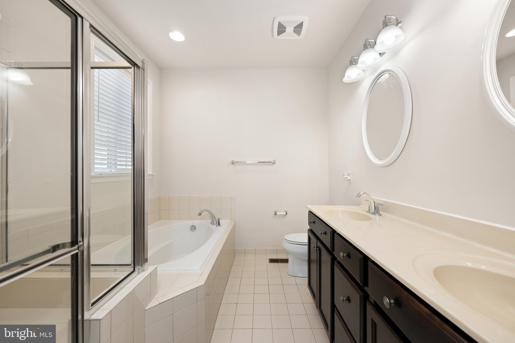 33057 Short Road Lewes, DE 19958 - Photo 13 of 40 a spacious bathroom with a double vanity sink toilet mirror and bathtub