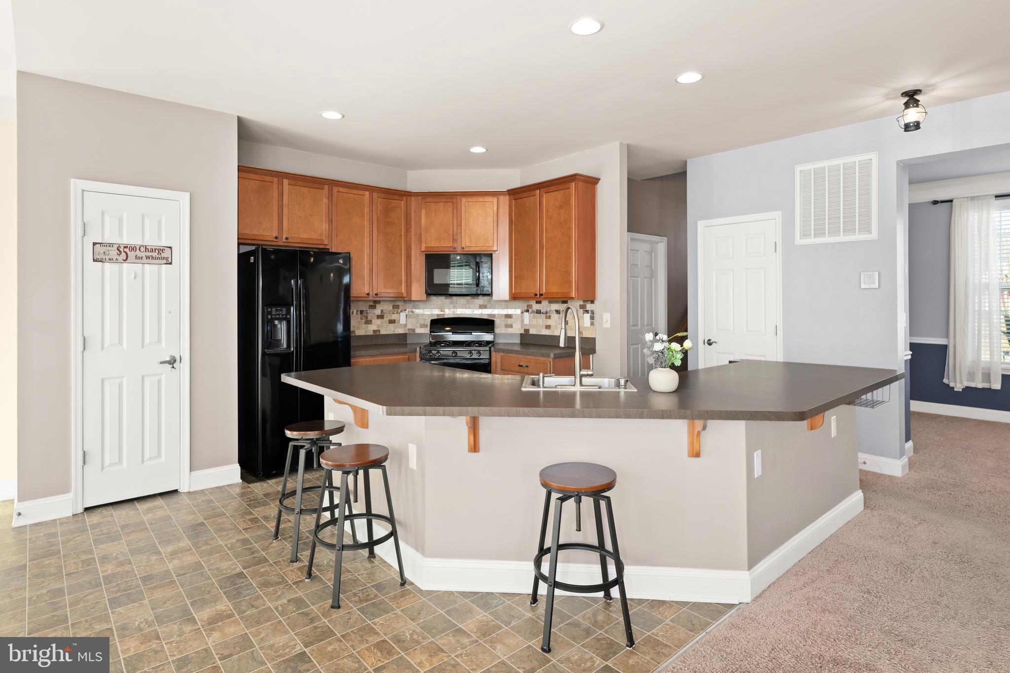 33057 Short Road Lewes, DE 19958 - Photo 5 of 40 a kitchen with stainless steel appliances granite countertop a sink a stove a refrigerator a dining table and chairs
