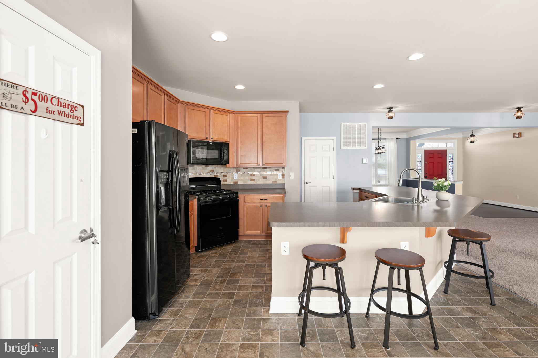 33057 Short Road Lewes, DE 19958 - Photo 7 of 40 a kitchen with stainless steel appliances kitchen island granite countertop a refrigerator and microwave
