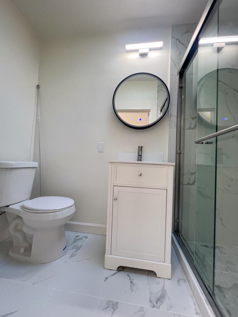 1206 Burlingame Avenue, Unit 1 Burlingame, CA 94010 - Photo 6 of 8 a bathroom with a toilet a sink and a mirror