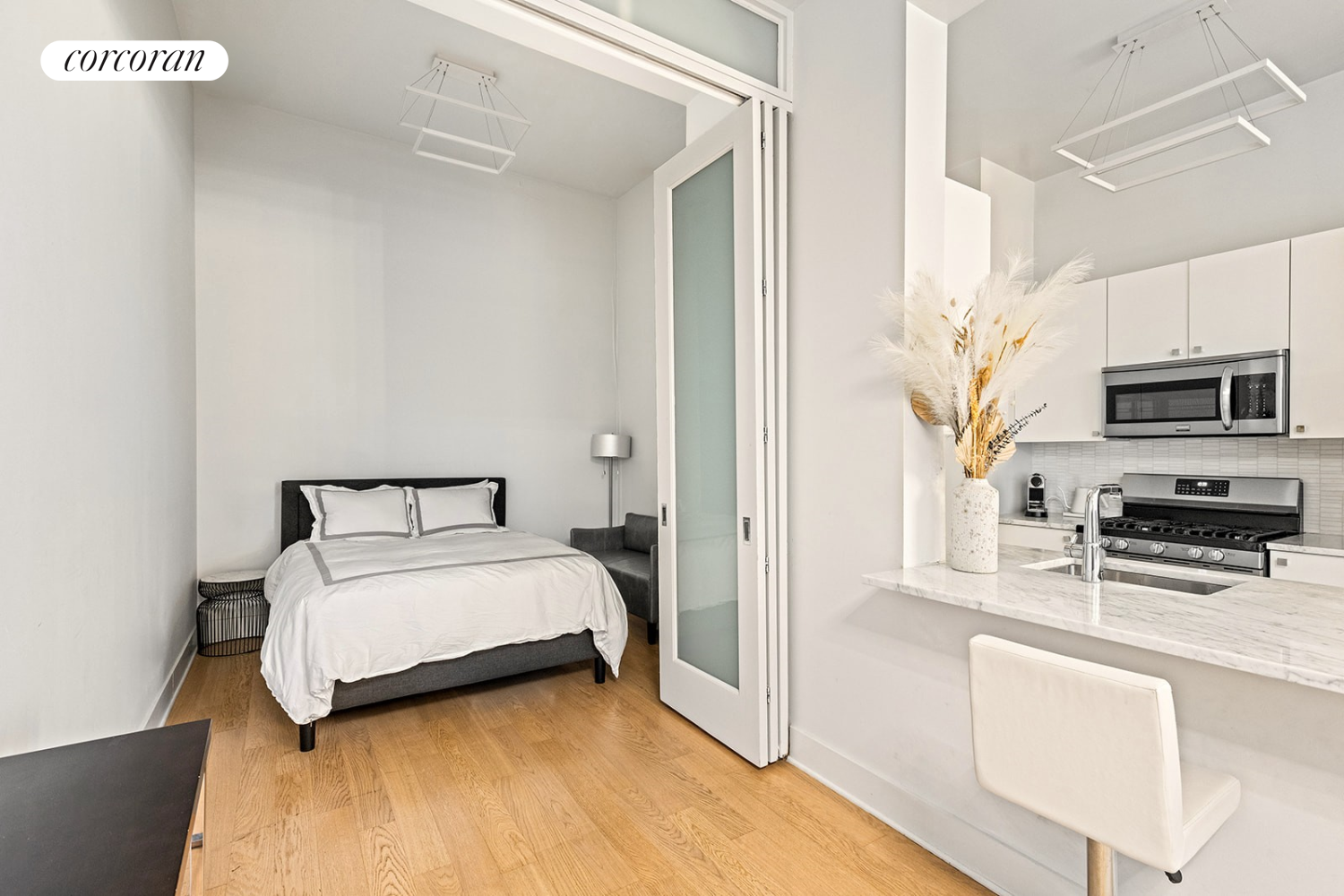 220 West 148th Street, Unit 5M Manhattan, NY 10039 - Photo 9 of 22 a spacious bedroom with a bed a microwave a stove and cabinets