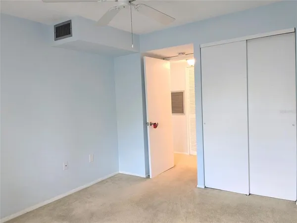 an empty room with a window and a ceiling fan