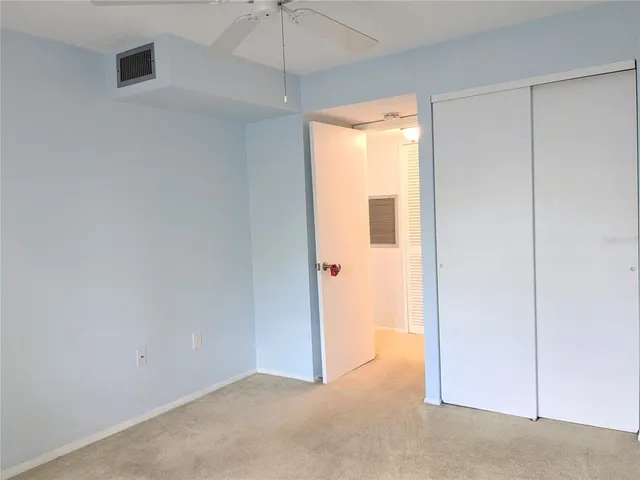 an empty room with a window and a ceiling fan