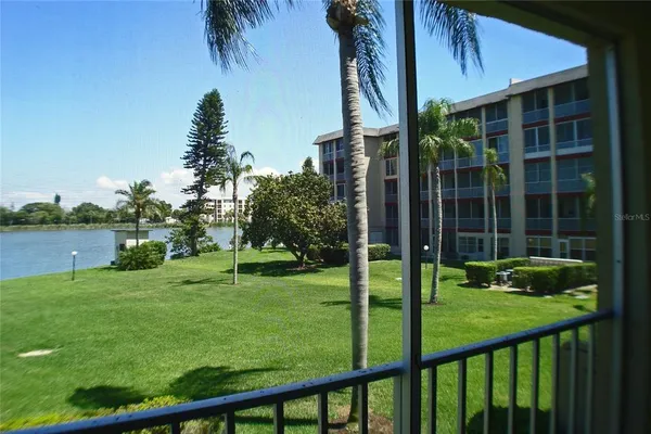 a view of a building with a garden and palm trees