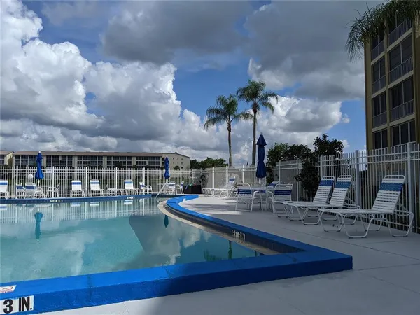 a view of a swimming pool with a patio and a yard
