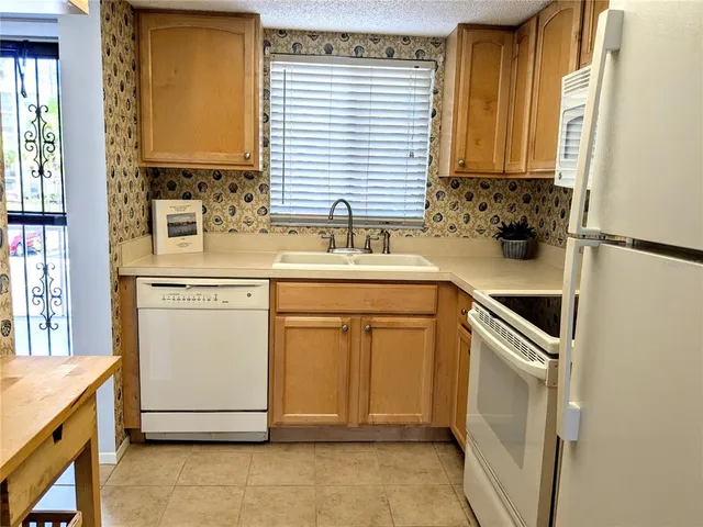 a kitchen with a sink cabinets appliances and a window