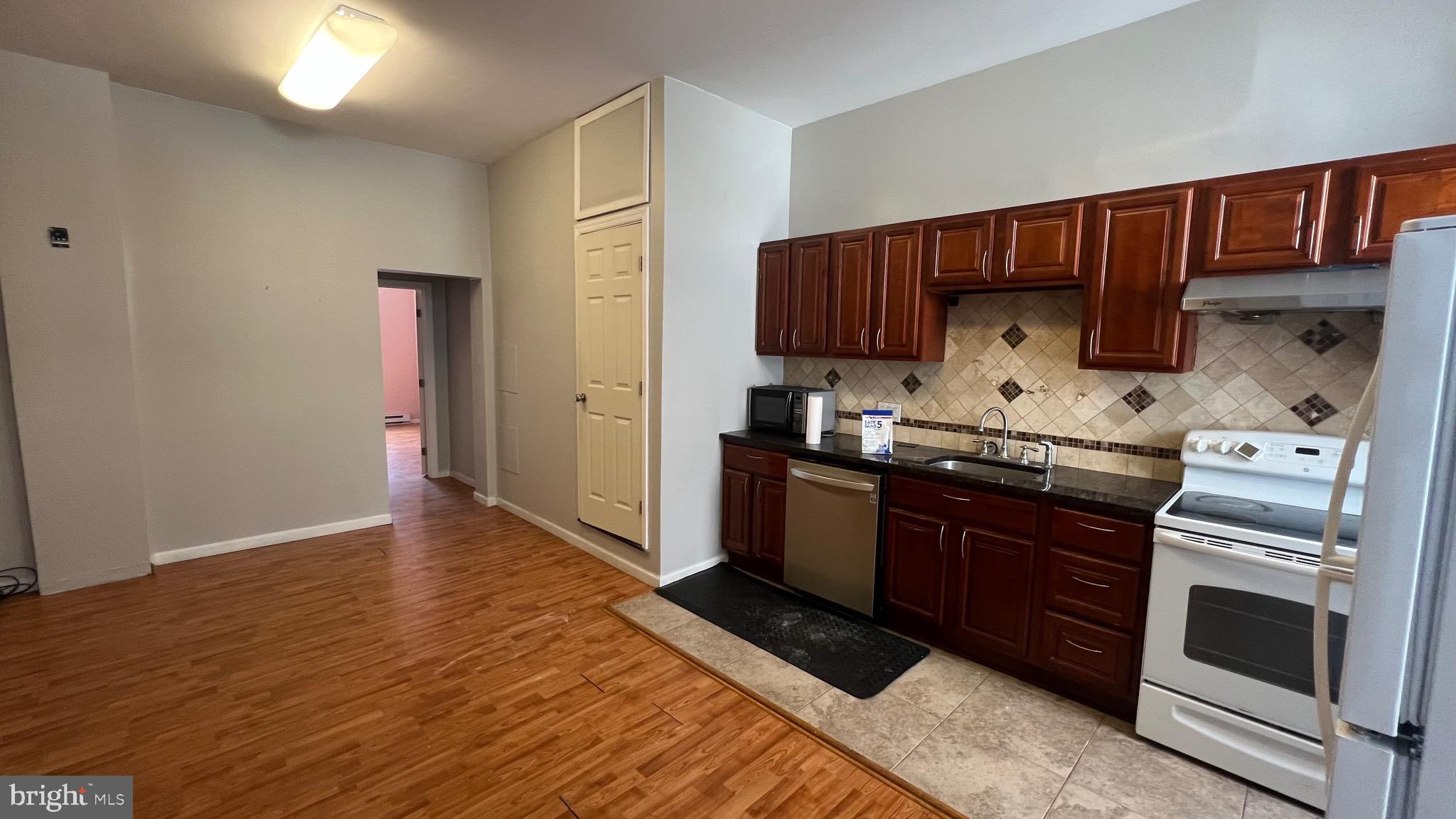 1115 Walnut Street, Unit 2F Philadelphia, PA 19107 - Photo 2 of 14 a kitchen with stainless steel appliances granite countertop a stove a sink and a refrigerator