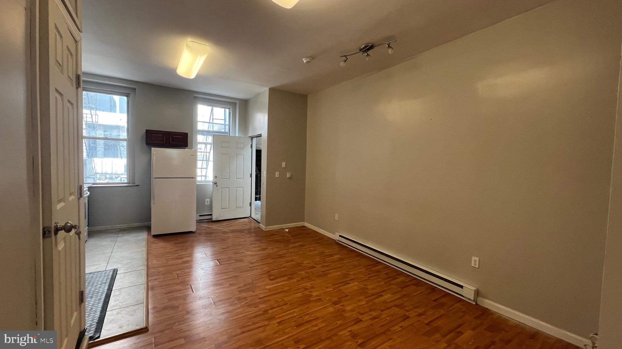 1115 Walnut Street, Unit 2F Philadelphia, PA 19107 - Photo 4 of 14 wooden floor in an empty room with a window