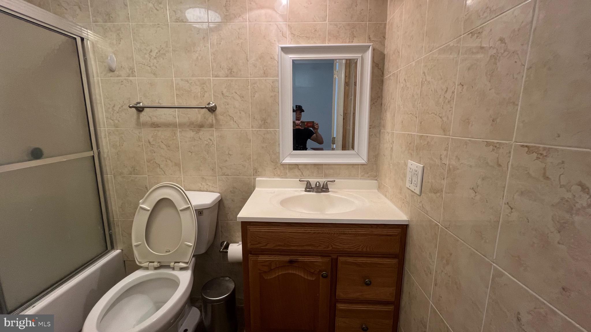 1115 Walnut Street, Unit 2F Philadelphia, PA 19107 - Photo 9 of 14 a bathroom with a toilet sink and mirror