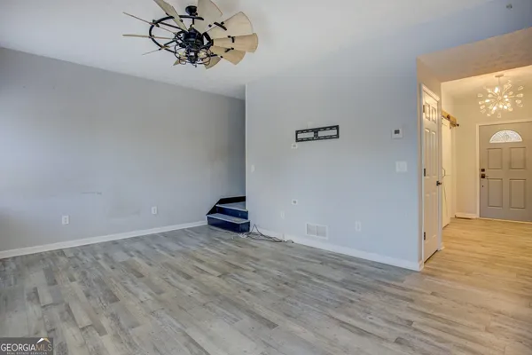 an empty room with wooden floor and mirror