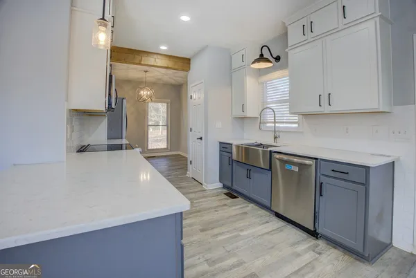 a large kitchen with stainless steel appliances a large counter top a stove and a refrigerator