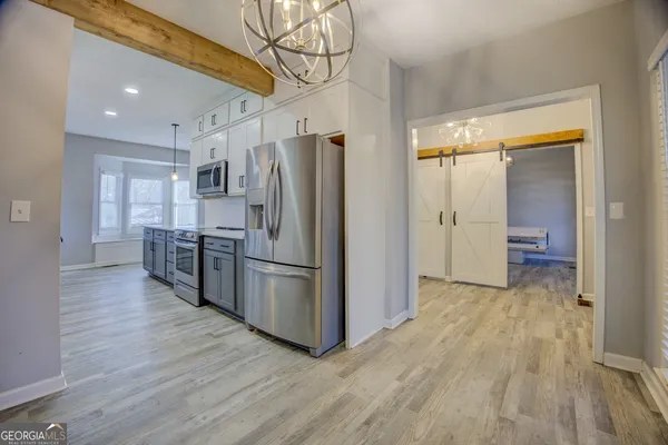 a kitchen with stainless steel appliances a refrigerator and wooden floor