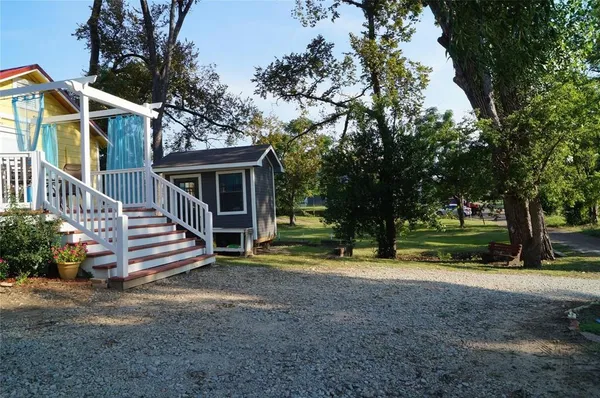 a view of a house with a yard and large trees