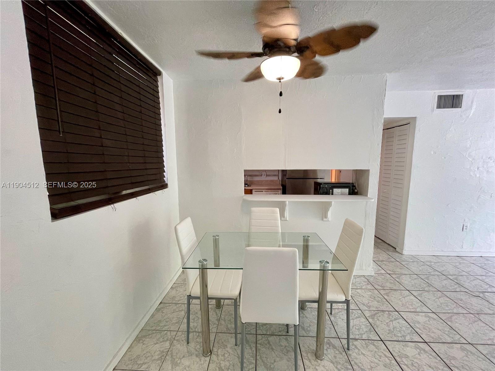 1670 Bay Road, Unit 2B Miami Beach, FL 33139 - Photo 11 of 15 a view of a dining room with furniture and chandelier