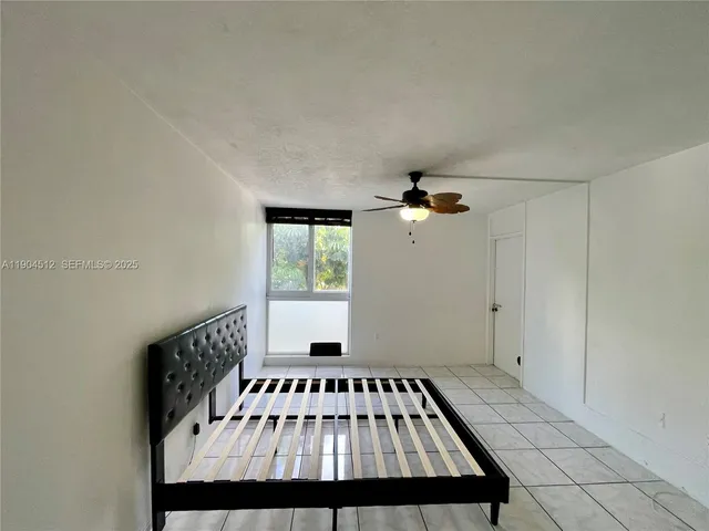 a view of a road with plants and large trees