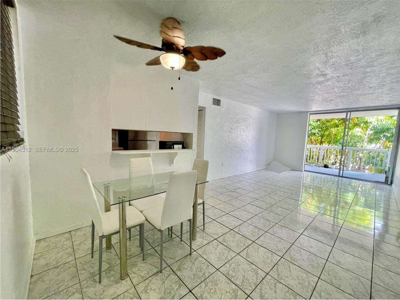 1670 Bay Road, Unit 2B Miami Beach, FL 33139 - Photo 2 of 15 a view of a dining room with furniture and a floor to ceiling window