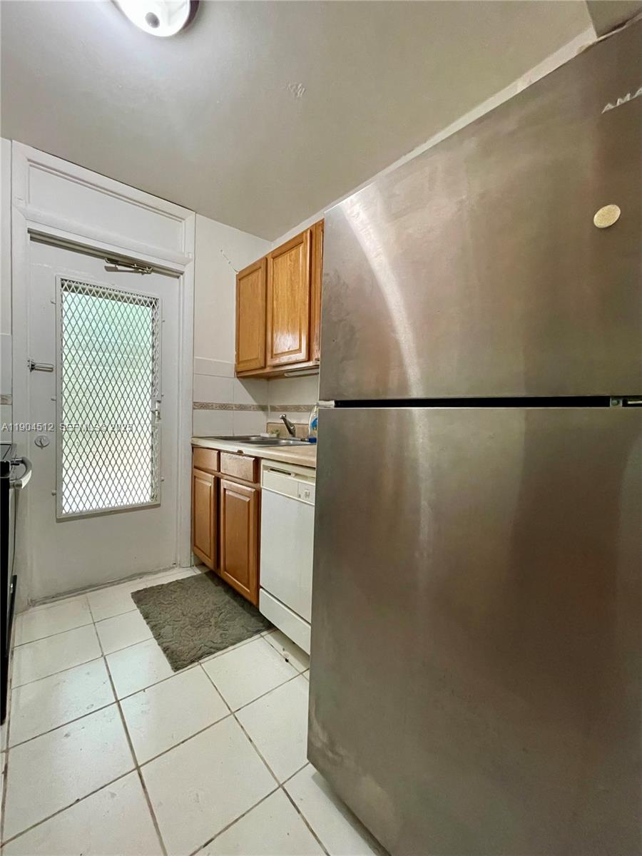 1670 Bay Road, Unit 2B Miami Beach, FL 33139 - Photo 9 of 15 a kitchen with a refrigerator a stove top oven and cabinets