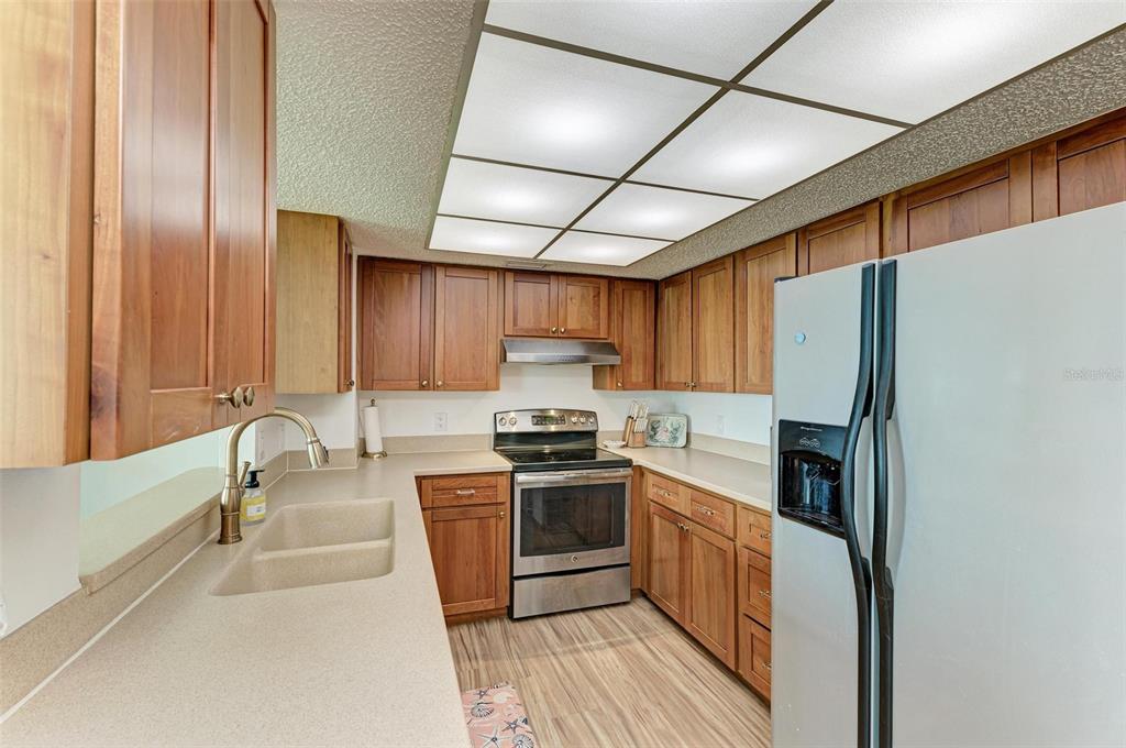 8735 Midnight Pass Road, Unit 107B Sarasota, FL 34242 - Photo 11 of 55 a kitchen with granite countertop a sink stainless steel appliances and cabinets