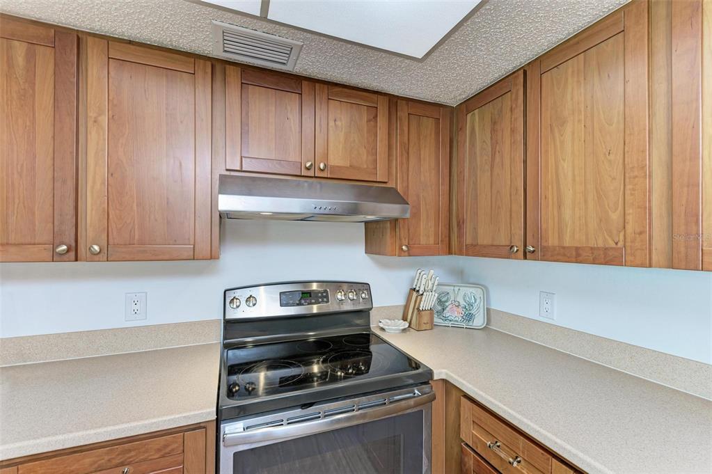 8735 Midnight Pass Road, Unit 107B Sarasota, FL 34242 - Photo 12 of 55 a kitchen with a stove and cabinets
