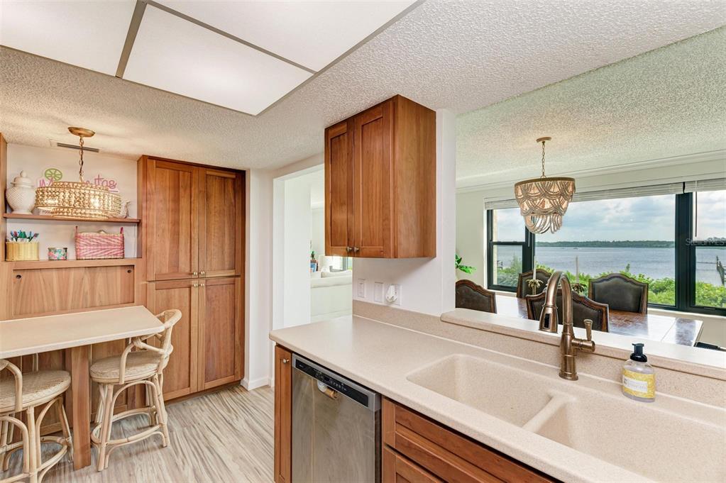 8735 Midnight Pass Road, Unit 107B Sarasota, FL 34242 - Photo 13 of 55 a kitchen with a sink cabinets and wooden floor