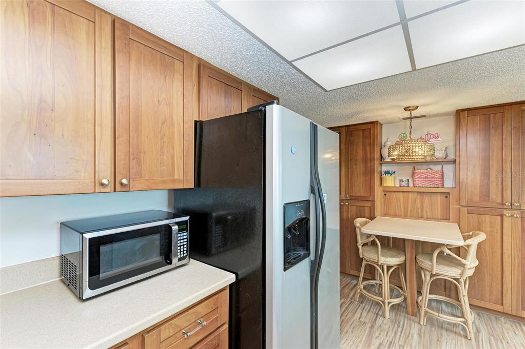 8735 Midnight Pass Road, Unit 107B Sarasota, FL 34242 - Photo 14 of 55 a kitchen with a refrigerator and a stove top oven