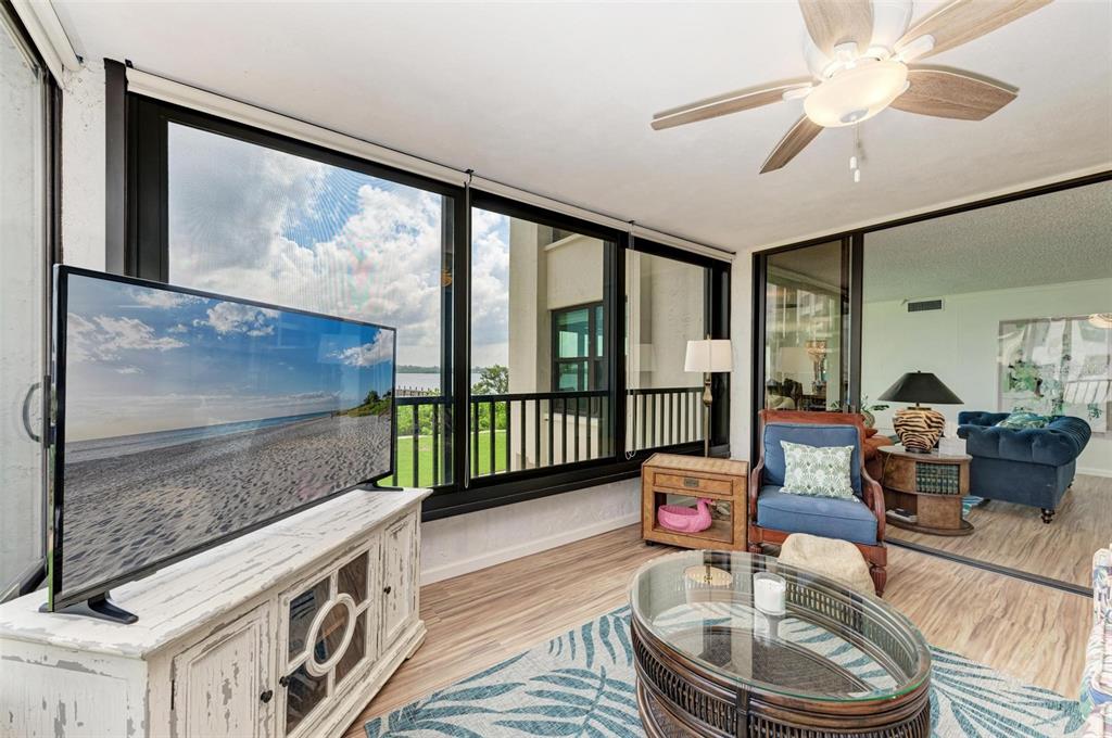 8735 Midnight Pass Road, Unit 107B Sarasota, FL 34242 - Photo 24 of 55 a living room with furniture and a floor to ceiling window