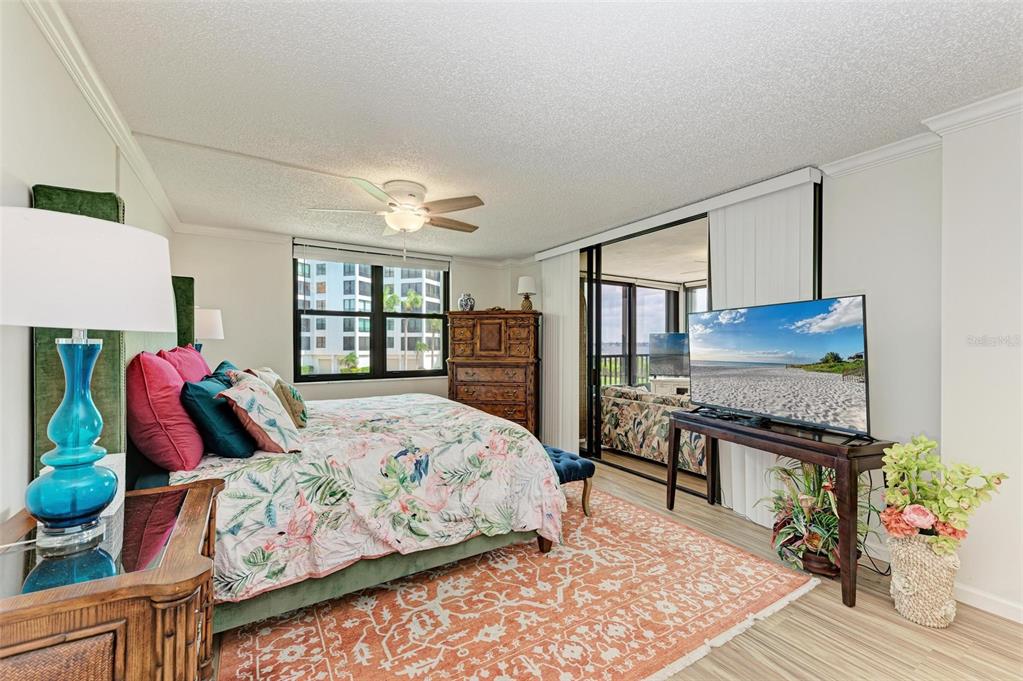 8735 Midnight Pass Road, Unit 107B Sarasota, FL 34242 - Photo 26 of 55 a bedroom with a bed and wooden floor