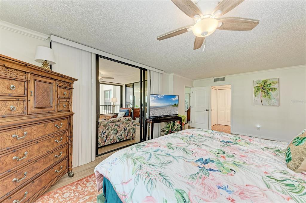8735 Midnight Pass Road, Unit 107B Sarasota, FL 34242 - Photo 27 of 55 a bedroom with a large bed and a chandelier