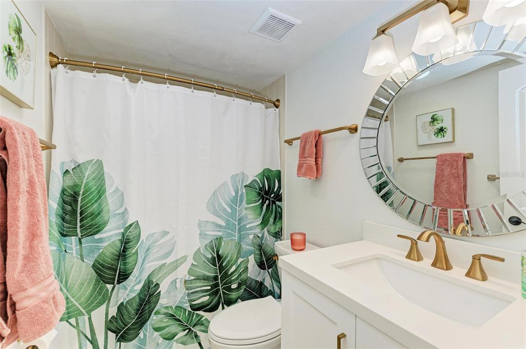 8735 Midnight Pass Road, Unit 107B Sarasota, FL 34242 - Photo 29 of 55 a bathroom with a sink a mirror and a toilet