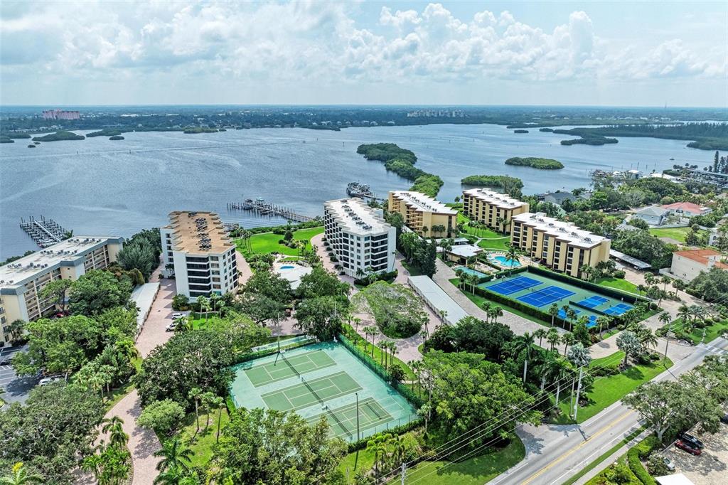 8735 Midnight Pass Road, Unit 107B Sarasota, FL 34242 - Photo 3 of 55 an aerial view of a house with a yard and lake view
