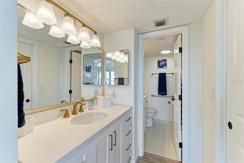 8735 Midnight Pass Road, Unit 107B Sarasota, FL 34242 - Photo 33 of 55 a bathroom with a sink vanity and a mirror