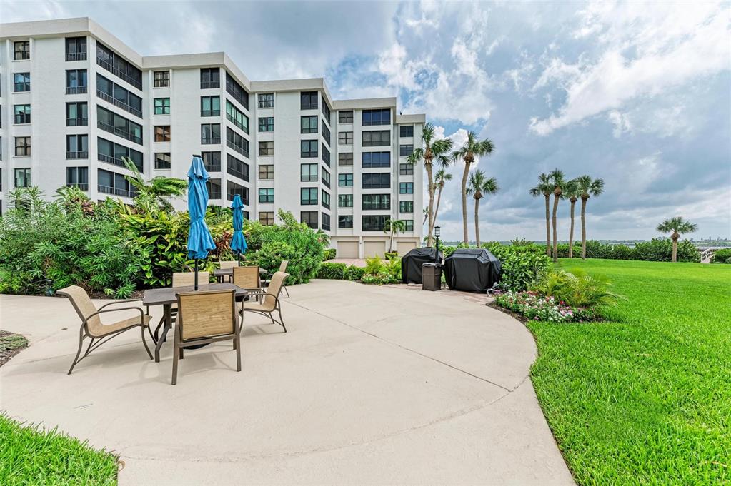 8735 Midnight Pass Road, Unit 107B Sarasota, FL 34242 - Photo 43 of 55 a view of a patio with a table and chairs and potted plants