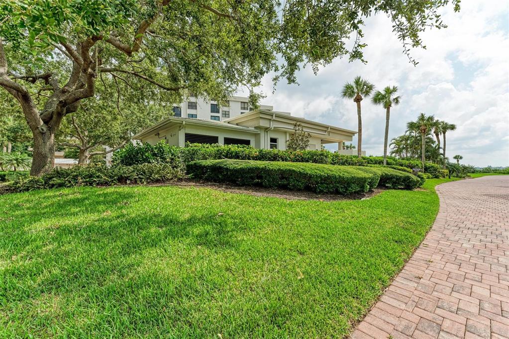 8735 Midnight Pass Road, Unit 107B Sarasota, FL 34242 - Photo 48 of 55 a view of a garden with a building in the background