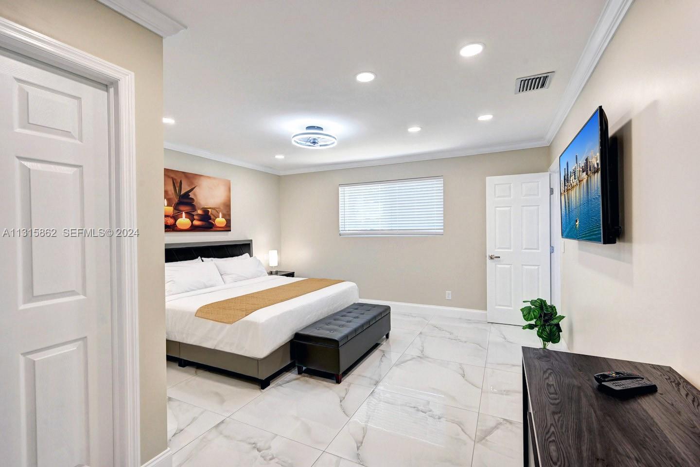 1307 Rodman Street Hollywood, FL 33019 - Photo 15 of 38 a bedroom with a bed and a potted plant
