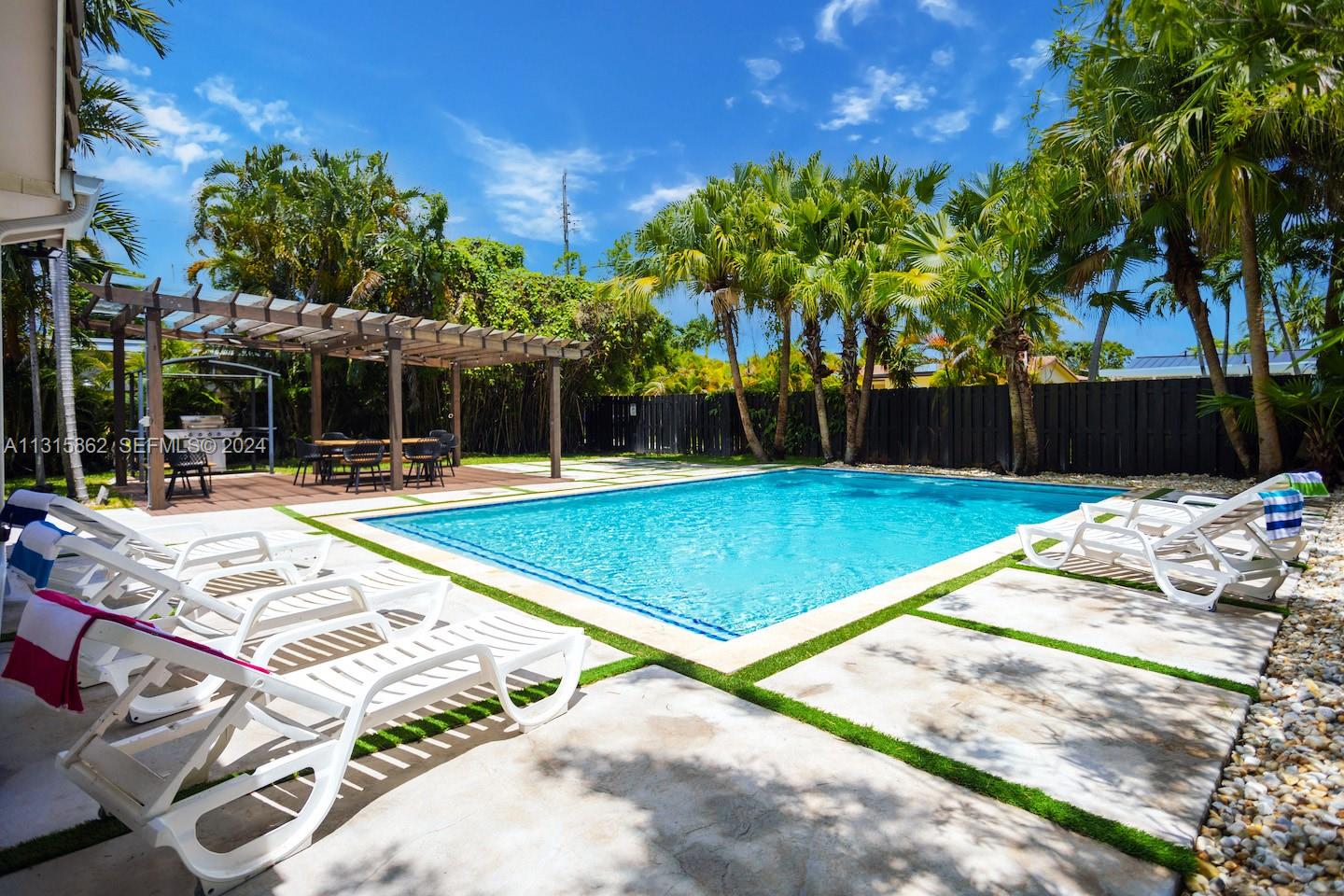 1307 Rodman Street Hollywood, FL 33019 - Photo 2 of 38 a view of a tennis ground with large trees