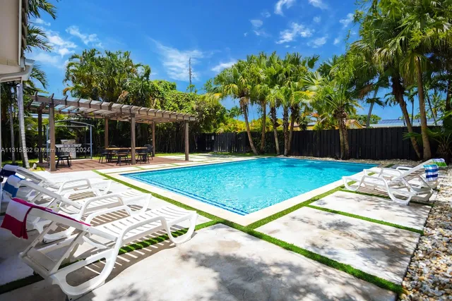 a swimming pool with outdoor seating and yard